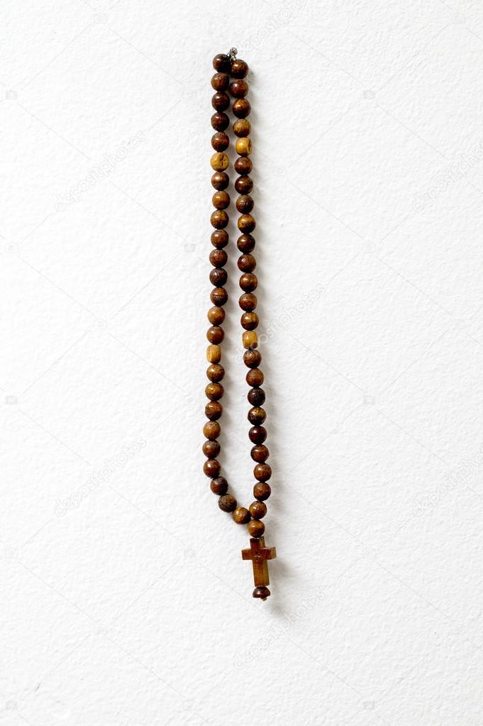 rosary beads  hanging against white wall