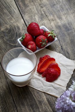 Kase ve süt ahşap masa backgro üzerinde taze olgun çilek