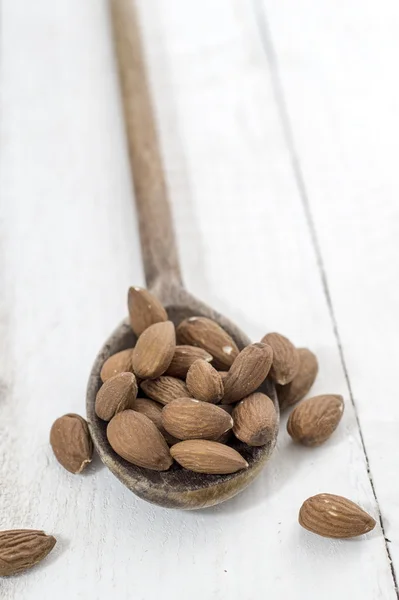 Almonds, white wooden table background — Stock Photo, Image
