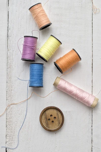 Bobbins with thread on the table — Stock Photo, Image