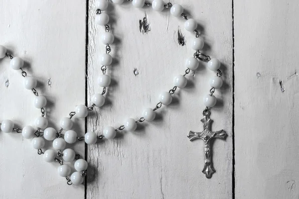 Rosary on rustic wooden surface — Stock Photo, Image