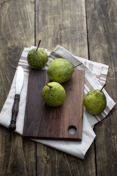 Peras frescas sobre tabla de cortar de madera —  Fotos de Stock
