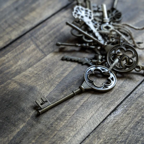 Bunch of vintage keys on old wooden plank — Stock Photo, Image