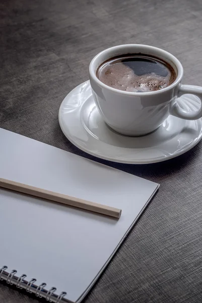 Um caderno branco em branco e uma xícara de café — Fotografia de Stock