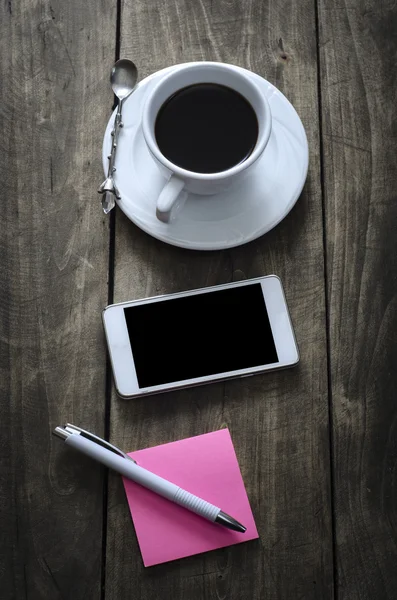 Telefono con tazza di caffè sulla vecchia scrivania in legno . — Foto Stock