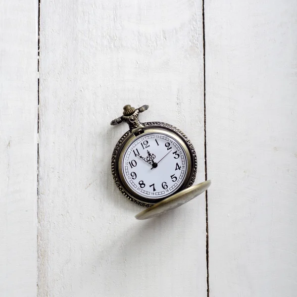 Pocket watch and chain against aged wood — Stock Photo, Image