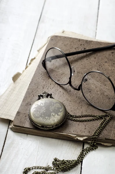 口袋里的手表、 眼镜和桌上的旧笔记本 — 图库照片