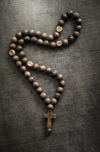 The rosary on old wooden table — Stock Photo, Image