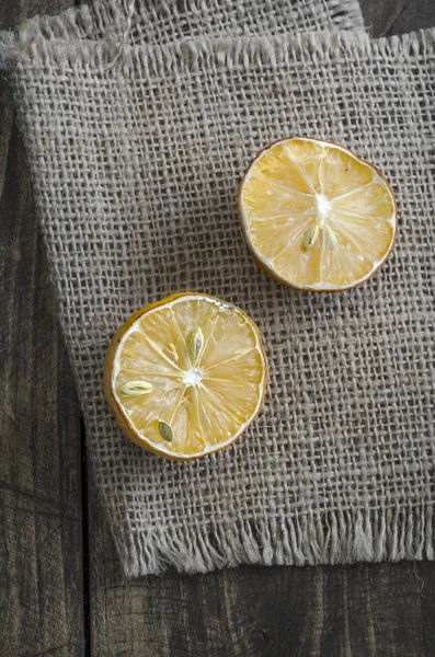 Tranches de citron séchées sur table en bois foncé rouillée — Photo