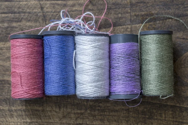 Bobbins with thread on the table — Stock Photo, Image