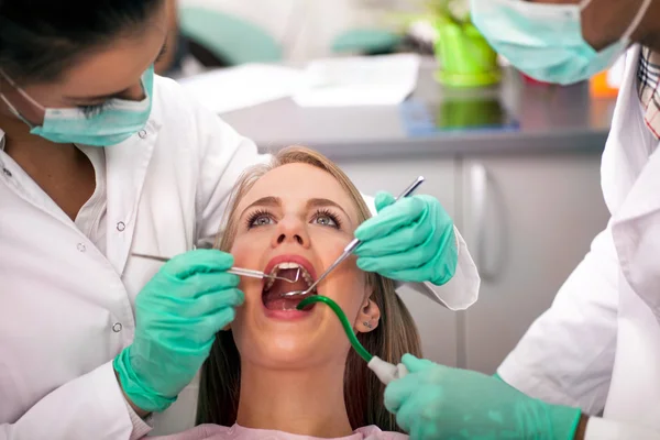 Dentiste traite les dents de la patiente — Photo