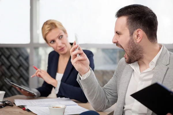 Frustrierter Geschäftsmann schreit am Telefon, drinnen — Stockfoto