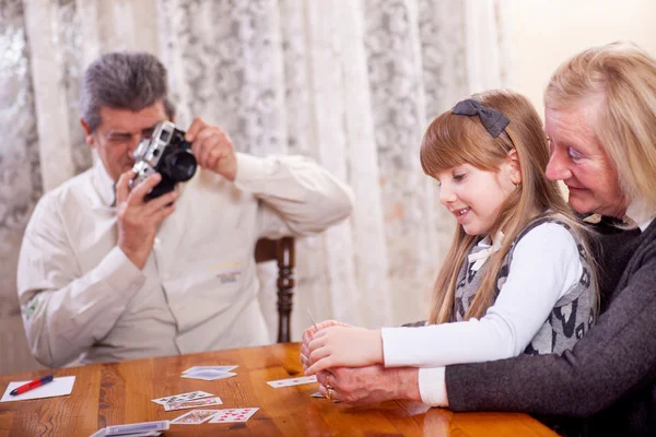 Happy senior couple playing with granddaughter — Stock Photo, Image