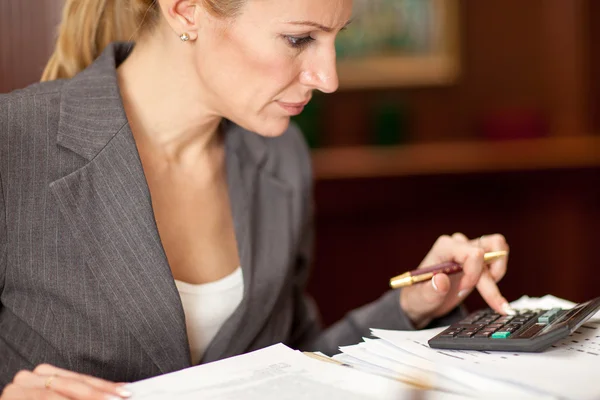 Donna d'affari seduta a un tavolo in ufficio e al lavoro — Foto Stock