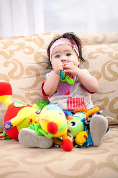 Baby speelt in de woonkamer op de Bank met speelgoed — Stockfoto