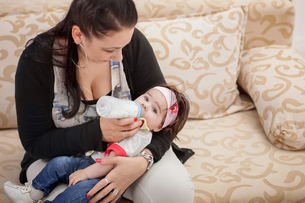 Madre alimentando a su pequeña niña del biberón —  Fotos de Stock