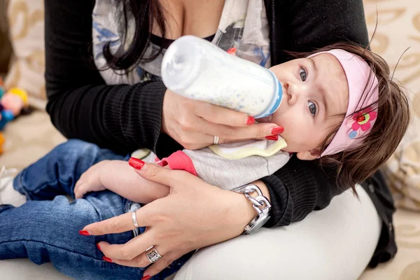 Madre alimentando a su pequeña niña del biberón —  Fotos de Stock