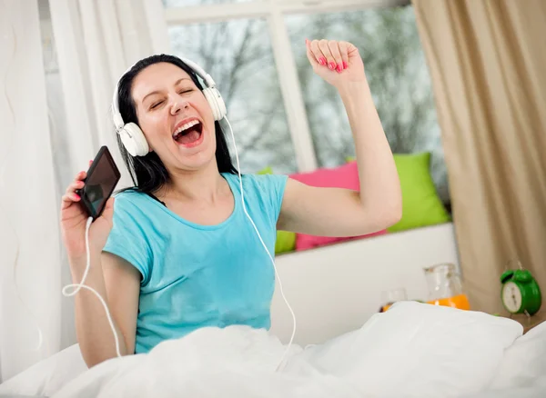 Chica en auriculares escuchando música desde el teléfono inteligente y dancin — Foto de Stock