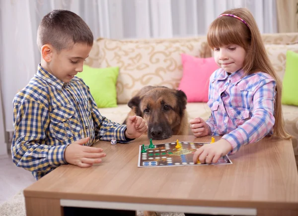 Kinderen spelen bordspel ludo thuis op de tafel — Stockfoto