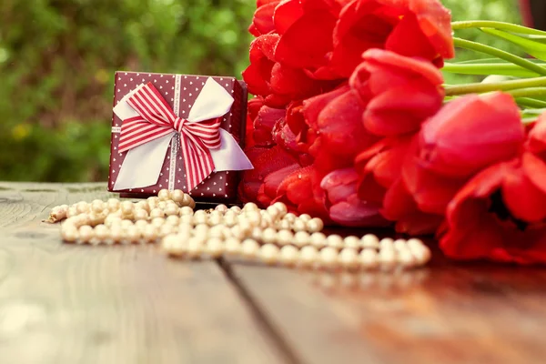 Mooie rode tulpen op houten achtergrond met geschenkdoos — Stockfoto