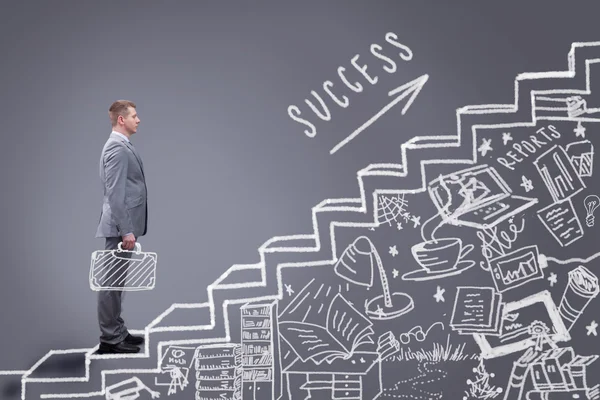 Businessman stands on career success stairs ,drawn on a chalkboa Stock Photo