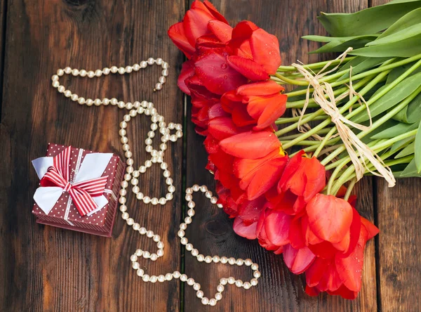 Mooie rode tulpen op houten achtergrond met geschenkdoos — Stockfoto