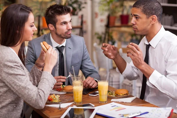 Gruppo di giovani uomini d'affari godono a pranzo al ristorante — Foto Stock