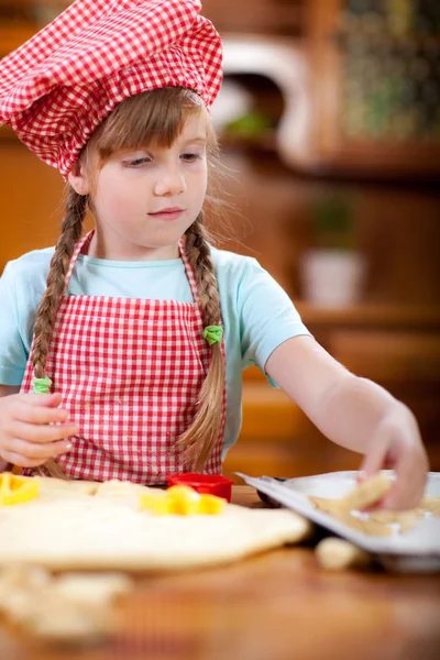 Glücklich lächelnde junge Köchin in der Küche, spielend — Stockfoto