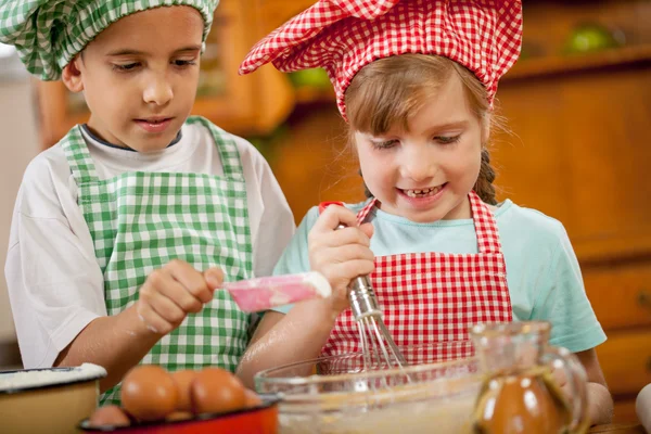 Niños sonrientes hacen un desastre en la cocina — Foto de Stock