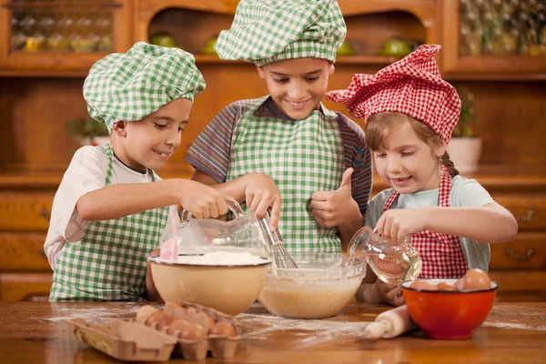 Les enfants souriants font un gâchis dans la cuisine — Photo