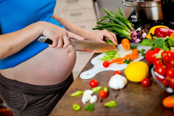 Donna incinta che taglia verdure fresche — Foto Stock