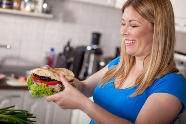 Hongerige zwangere vrouw eatinga grote hamburger, junkfood. — Stockfoto
