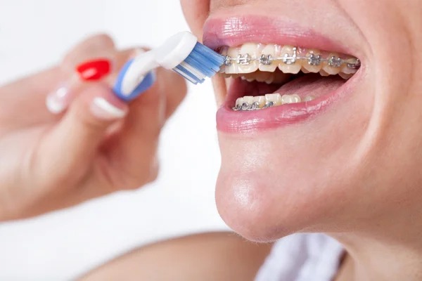 Närbild face av ung kvinna borsta hennes tänder med en plast t — Stockfoto