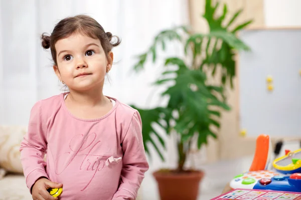 Divertida niña preescolar jugando con juguetes en la habitación — Foto de Stock