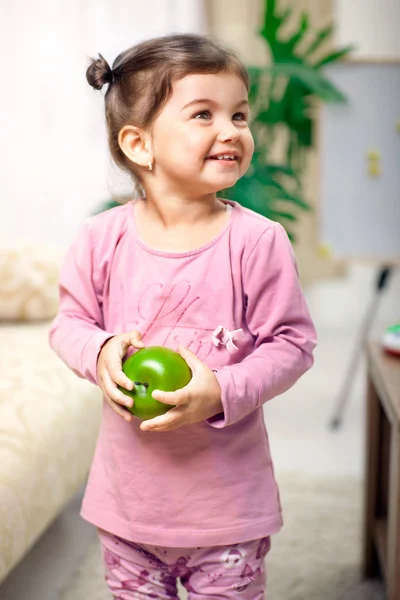 Mignonne petite fille dans la chambre avec pomme verte — Photo