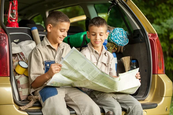 Famiglia con auto nella natura lettura mappa e campeggio — Foto Stock