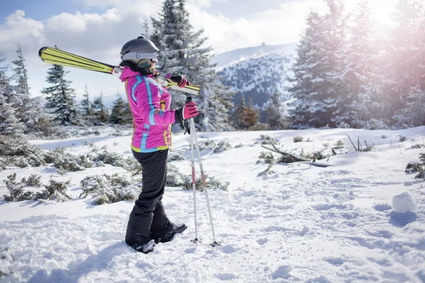 Glada skidåkare kvinna som står på ett berg täckta med snö — Stockfoto