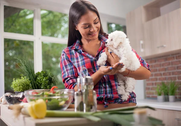 Beautiful young Filipina girl with small Bichon dog in the kitch — Stock Photo, Image