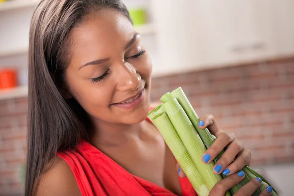 Femme souriante dans la cuisine avec poireau de légumes biologiques — Photo