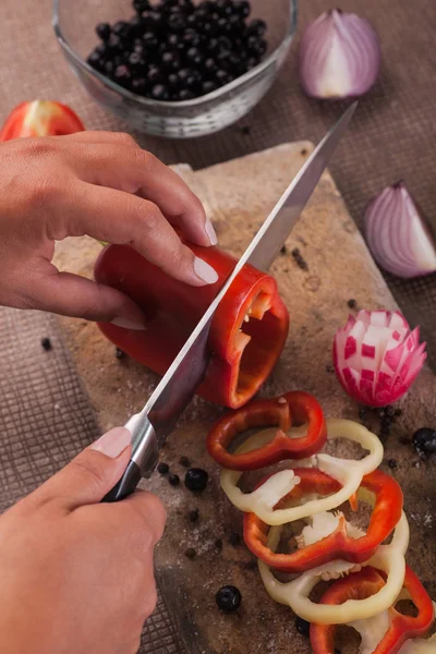 Vrouwelijke handgekapte rode paprika met mes — Stockfoto