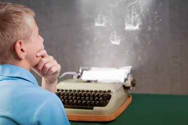 Retro daktiloda yazmaya şirin küçük çocuk