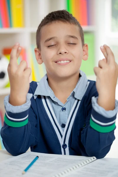 Schoolboy keeps fingers crossed — Stock Photo, Image