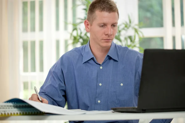 Hombre de negocios guapo trabajando con el ordenador portátil en la oficina —  Fotos de Stock