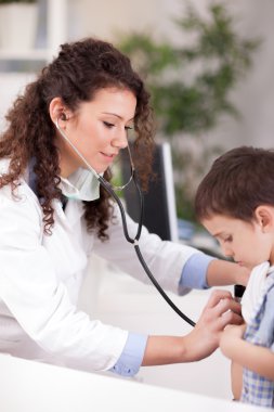  Kadın Doktor çocuk stetoskop ile inceliyor.