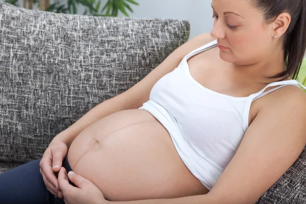 Junge schöne schwangere Frau streichelt in ihrem großen Bauch — Stockfoto
