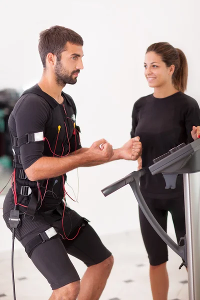 Vrouwelijke coach geven man ems electro spierstimulatie exercis — Stockfoto