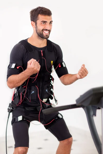 Young fit man exercise biceps curl on  electro muscular stimulat — Stock Photo, Image