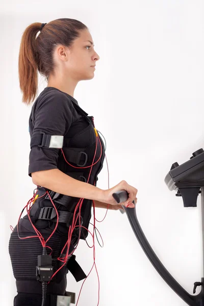 Jonge passen vrouw oefenen op electro spierstimulatie machine — Stockfoto