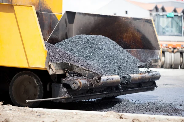 Paver rastreado que estabelece pavimento de asfalto fresco durante a construção da estrada — Fotografia de Stock