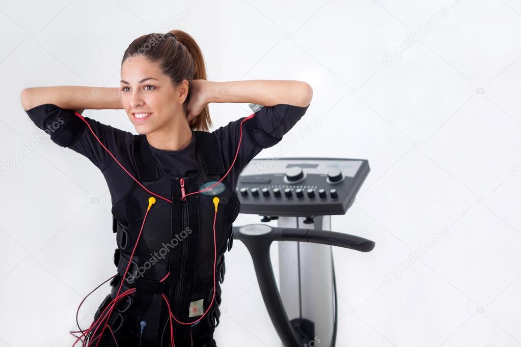 young fit woman exercise on electro muscular stimulation machine